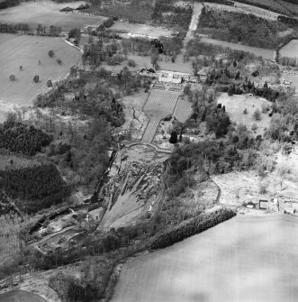 Oblique aerial view centred on the drained formal pond within Mellerstain House garden with country house and stables adjacent, taken from the ESE.