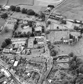 General oblique aerial view of Melrose centred on Harmony house and the remains of the abbey, taken from the SE.