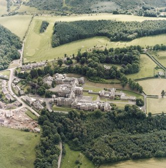 Oblique aerial view centred on the asylum and hospital, taken from the NW.