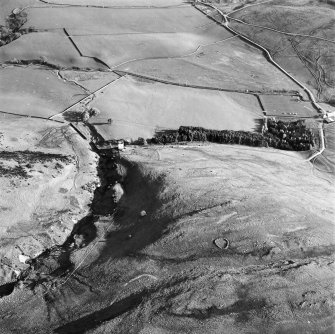 Oblique aerial view centred on the remains of the tower with the field system and tower adjacent, taken from the NNW.