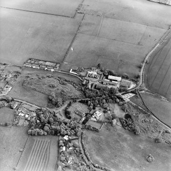 Oblique aerial view centred on the farmsteadings, church and burial ground with village adjacent, taken from the WNW