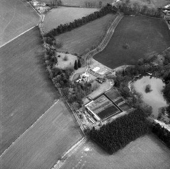 Oblique aerial view centred on country house from NW.