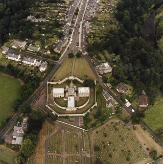 Oblique aerial view centred on the jail, burial ground and The Hermitage, taken from the SW.