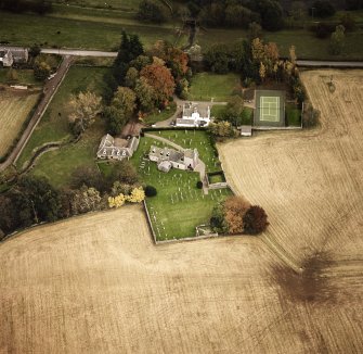 Oblique aerial view centred on the church and manse, taken from the NW.