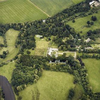 Oblique aerial view centred on the tower-house and country house with the gardens and ancillary buildings adjacent, taken from the NW.