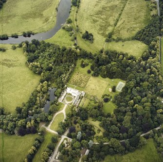 Oblique aerial view centred on the tower-house and country house with the gardens and ancillary buildings adjacent, taken from the SW.