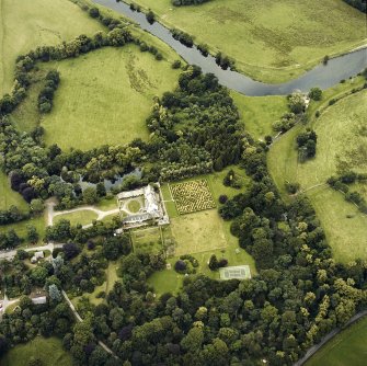 Oblique aerial view centred on the tower-house and country house with the gardens and ancillary buildings adjacent, taken from the SSE.