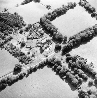 Oblique aerial view centred on the country house with the stables adjacent, taken from the N.
