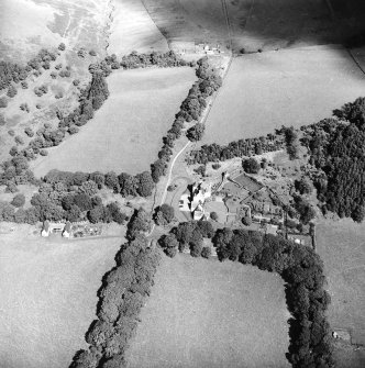 Oblique aerial view centred on the country house with the stables adjacent, taken from the SW.