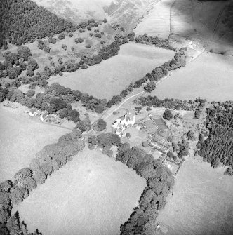 Oblique aerial view centred on the country house with the stables adjacent, taken from the SSW.