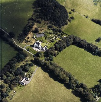 Oblique aerial view centred on the country house with the stables adjacent, taken from the WNW.