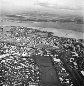 General oblique aerial view looking over the oil refinery across the River Forth towards Fife, taken from the W.