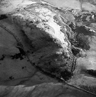 Oblique aerial view centred on the radio station and the remains of the fort with the quarry adjacent, taken from the NW.