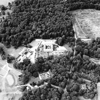 Oblique aerial view centred on the stable with club house and country house adjacent, taken from the SE.
