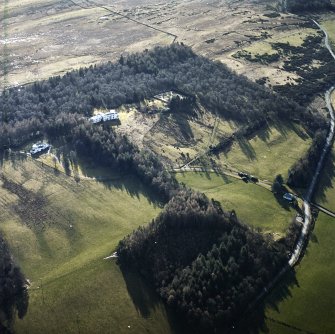 Oblique aerial view centred on the country house with garage block, walled garden and lodge adjacent, taken from the NE.