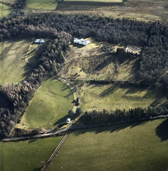 Oblique aerial view centred on the country house with garage block, walled garden and lodge adjacent, taken from the NNW.