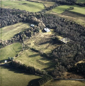 Oblique aerial view centred on the country house with garage block, walled garden and lodge adjacent, taken from the NW.