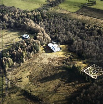 Oblique aerial view centred on the country house with garage block and walled garden adjacent, taken from the NW.