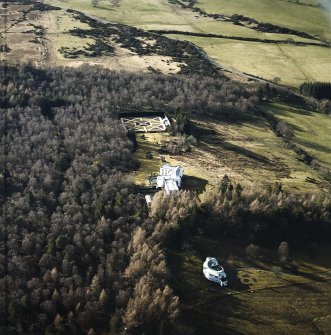 Oblique aerial view centred on the country house with garage block and walled garden adjacent, taken from the E.