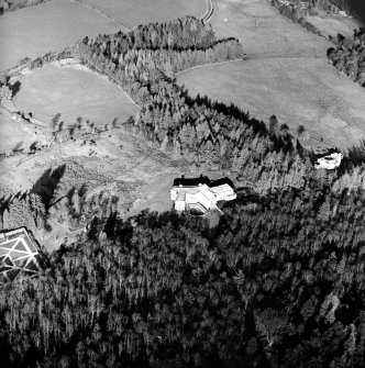 Oblique aerial view centred on the country house with garage block adjacent, taken from the S.