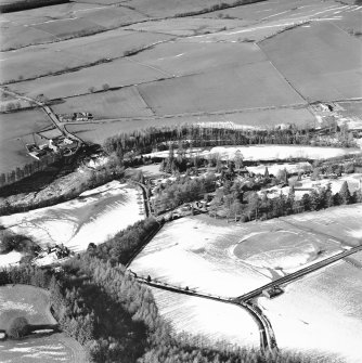 Balgray House and Lammonbie, oblique aerial view, taken from the SE, centred on a cricket ground and lodge. Lammonbie farmsteading and cottages and a road bridge are visible in the centre left-hand side of the photograph.