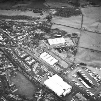 Oblique aerial view from SW, centred on two L type hangars and the site of a third.