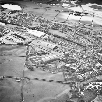 Oblique aerial view from ENE, centred on hangars and various other buildings.