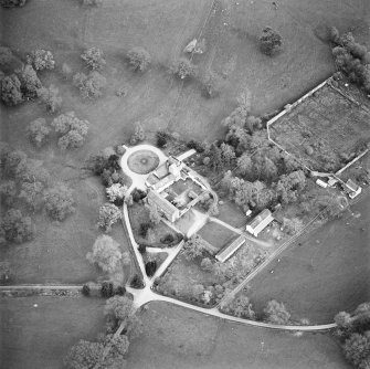 Oblique aerial view centred on the tower-house, stables and outbuildings, taken from the WNW.