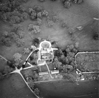 Oblique aerial view centred on the tower-house, stables and outbuildings, taken from the WSW.