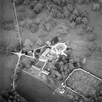 Oblique aerial view centred on the tower-house, stables and outbuildings, taken from the SW.