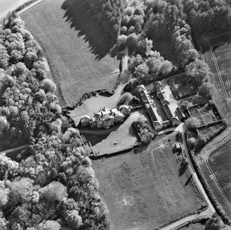 Oblique aerial view centred on the country house and stables, taken from the NE.