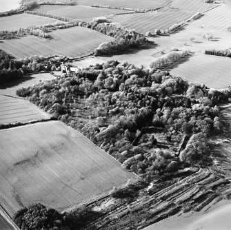 Oblique aerial view centred on the country house, stables, gardens and walled garden, taken from the SSE.