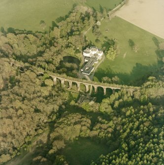 Oblique aerial view centred on the country house, railway viaduct and stables, taken from the WNW.