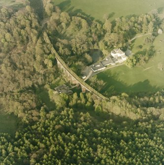 Oblique aerial view centred on the country house, railway viaduct and stables, taken from the WSW.