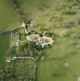 Oblique aerial view centred on the tower-house, stables and outbuildings, taken from the SSE.