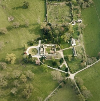 Oblique aerial view centred on the tower-house, stables and outbuildings, taken from the N.