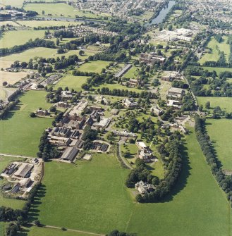 General oblique aerial view centred on the hospital and the church, taken from the SE.
