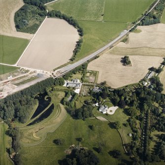 Oblique aerial view centred on the country house and garden with the lodge adjacent, taken from the WNW.