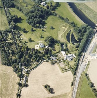 Oblique aerial view centred on the country house and garden with the lodge adjacent, taken from the SE.