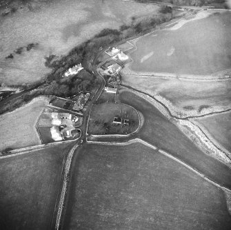 Oblique aerial view centred on church and burial ground from S.