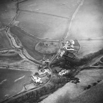 Oblique aerial view centred on church and burial ground from N.