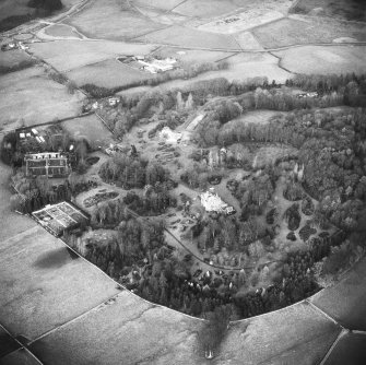 Oblique aerial view centred on house from SW.