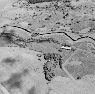 Oblique aerial view centred on part of Unit 2 of the explosives works and armament depot (W of Kirkgunzeon Lane) showing the surviving production houses and earthworks, taken from the WSW.