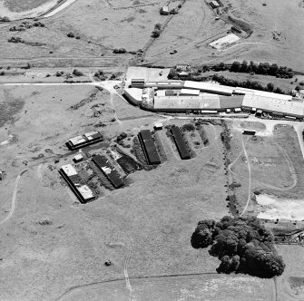 Oblique aerial view centred on Unit 2 of the explosives works and armament depot, showing the former canteen and gun cotton laoding station with five production houses, air-raid shelters and an observation tower, taken from the NNW.