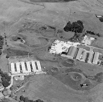 Oblique aerial view centred on Unit 2 of the explosives works and armament depot, showing the earthworks for the burette and charge houses with a type 24 pillbox. taken from the SW.
Also visible is Edingham Industrial Estate with Edingham farm poultry houses.