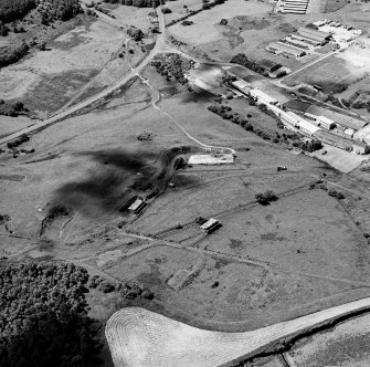 Oblique aerial view centred on the S part of the explosives works and armament depot showing the magazine area, cordite loading station and the earthworks for internal tranway system from the NE.