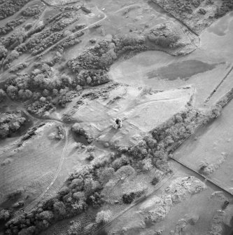 Oblique aerial view centred on the remains of the tower-house, possible garden, buildings and rig, taken from the N.