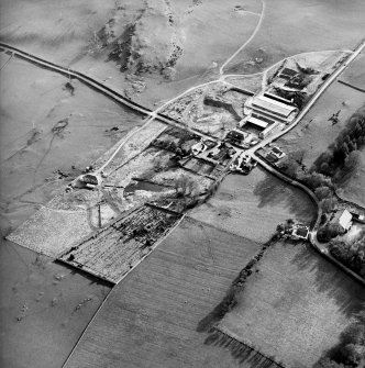 Oblique aerial view centred on the farmsteading with church and burial grounds adjacent, taken from the NNE