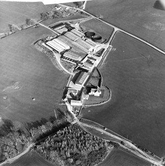 Oblique aerial view centred on the farmstead with the site of the well adjacent, taken from the W