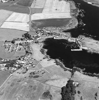 Oblique aerial view centred on the village and harbour with the remains of the chapel adjacent, taken from the SW.